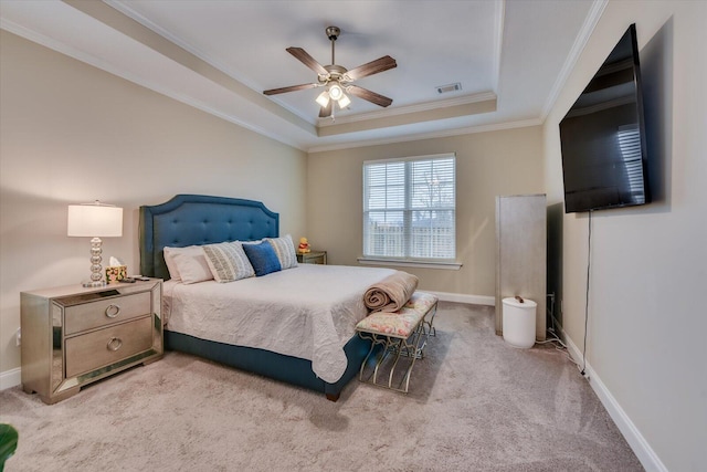 bedroom with a raised ceiling, crown molding, light carpet, and ceiling fan