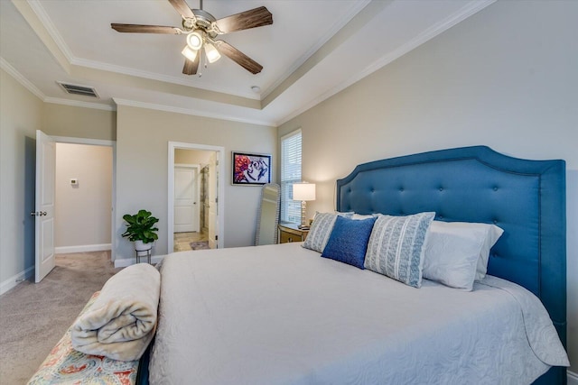 carpeted bedroom with crown molding, ceiling fan, and a raised ceiling