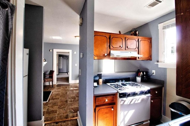 209 Ellis St, Augusta, GA 30901 - kitchen featuring white gas range oven, under cabinet range hood, and brown cabinets