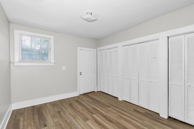 209 Ellis St, Augusta, GA 30901 - unfurnished bedroom featuring two closets and wood finished floors