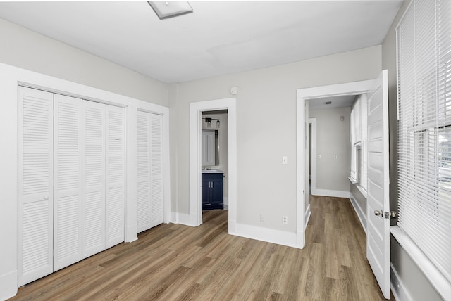 209 Ellis St, Augusta, GA 30901 - unfurnished bedroom with wood finished floors, ensuite bathroom, and multiple closets