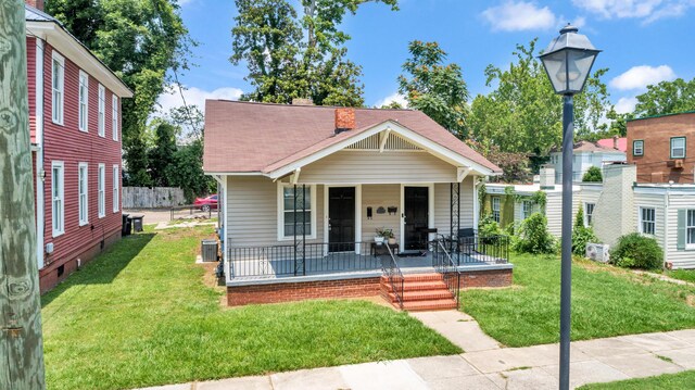 209 Ellis St, Augusta, GA 30901 - view of front of home with covered porch, a front lawn, a chimney, and roof with shingles