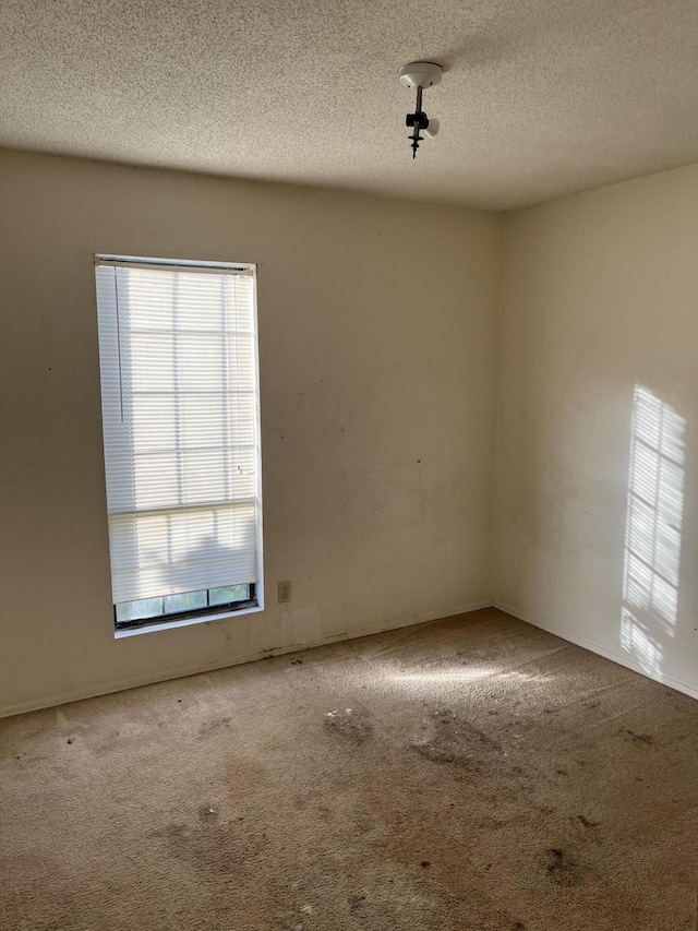 unfurnished room featuring carpet floors and a textured ceiling