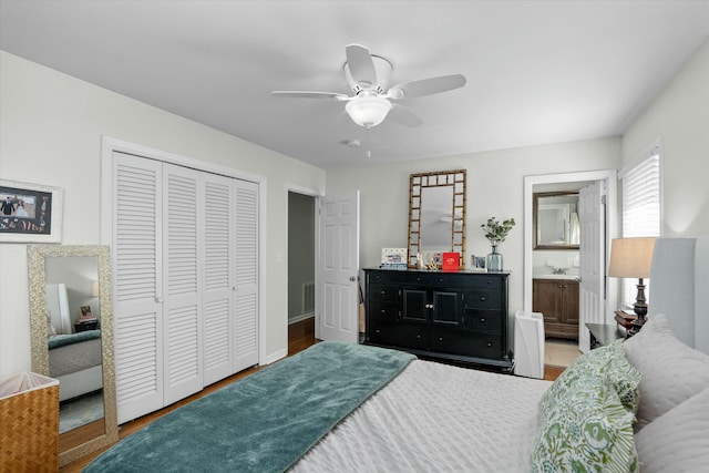 bedroom with ceiling fan, connected bathroom, hardwood / wood-style floors, and a closet