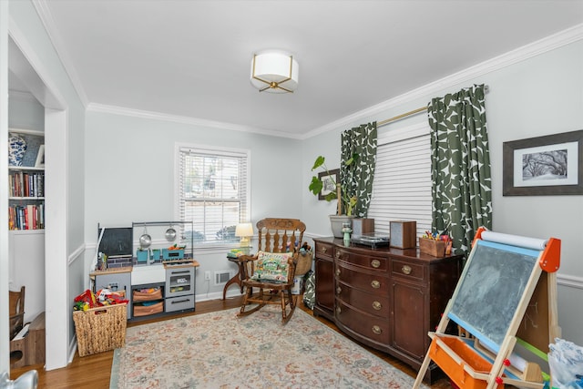 sitting room featuring ornamental molding and light wood-type flooring