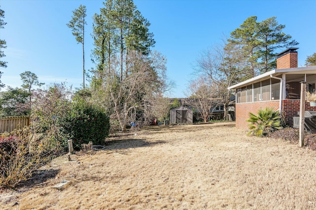 view of yard featuring a sunroom and a shed