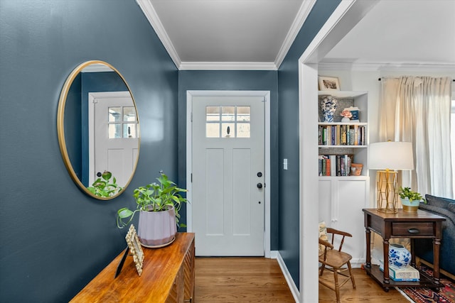 foyer entrance with ornamental molding and light hardwood / wood-style flooring