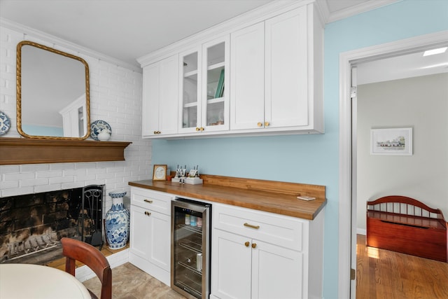 bar featuring white cabinetry, ornamental molding, beverage cooler, and butcher block countertops