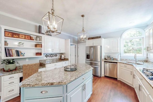kitchen featuring a sink, white cabinets, stainless steel appliances, and a chandelier