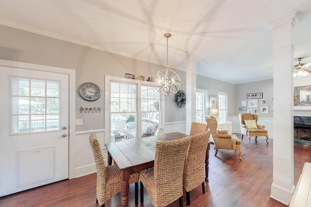 dining area with crown molding, wainscoting, decorative columns, and dark wood finished floors