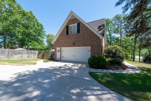 view of side of home featuring concrete driveway, brick siding, fence, and a garage