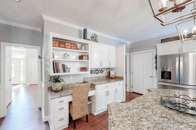 kitchen with stainless steel refrigerator with ice dispenser, open shelves, dark wood finished floors, built in desk, and white cabinetry