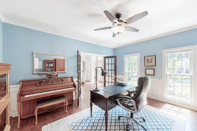 office space with crown molding, wainscoting, ceiling fan, and wood finished floors