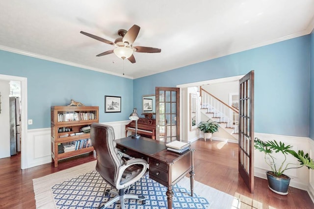 office space with french doors, a wainscoted wall, a ceiling fan, wood finished floors, and ornamental molding