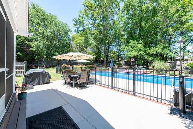 view of swimming pool with a fenced backyard, a fenced in pool, outdoor dining area, and a patio