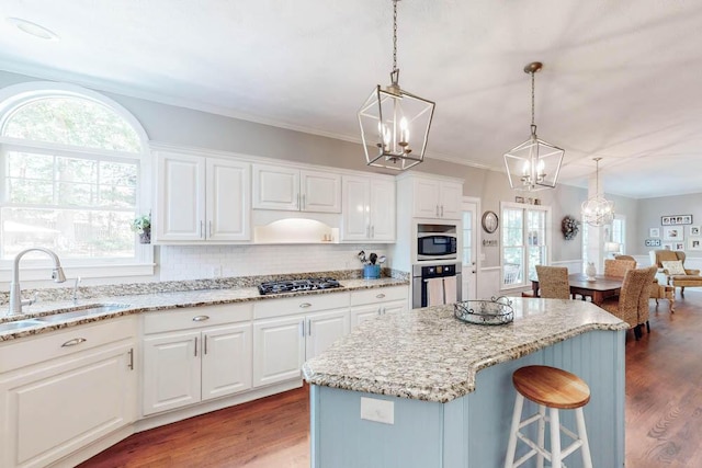 kitchen featuring stainless steel appliances, a chandelier, a wealth of natural light, and a sink
