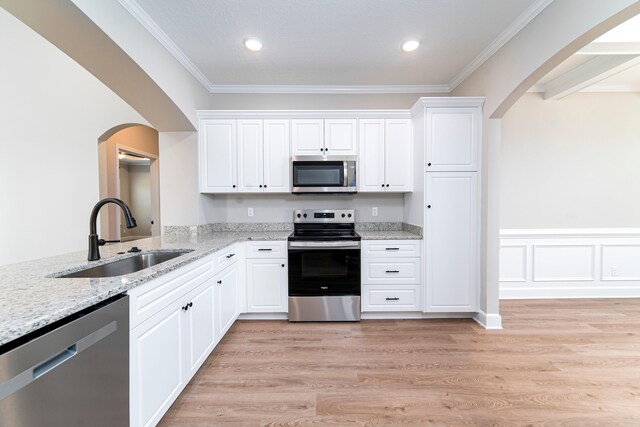 645 Jet Pass, Beech Island, SC 29842 - kitchen with appliances with stainless steel finishes, a sink, arched walkways, light stone counters, and white cabinetry