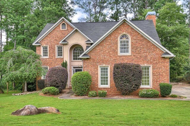 3696 El Cordero Ranch Springs Rd, Augusta, GA 30907 - traditional-style house featuring a front yard, a chimney, a shingled roof, and brick siding