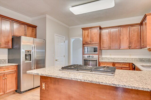 3696 El Cordero Ranch Springs Rd, Augusta, GA 30907 - kitchen featuring appliances with stainless steel finishes, crown molding, light wood-type flooring, light stone countertops, and brown cabinetry