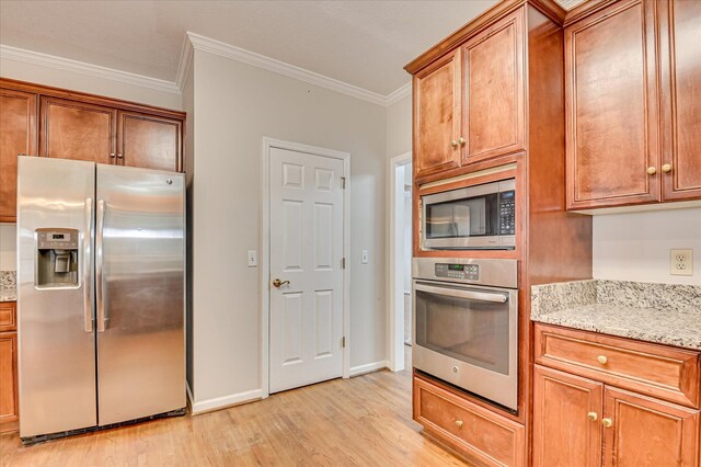 3696 El Cordero Ranch Springs Rd, Augusta, GA 30907 - kitchen with stainless steel appliances, light wood-style floors, ornamental molding, light stone counters, and brown cabinets