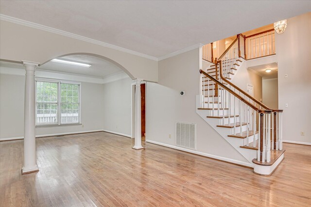 3696 El Cordero Ranch Springs Rd, Augusta, GA 30907 - unfurnished living room featuring decorative columns, wood finished floors, baseboards, arched walkways, and crown molding