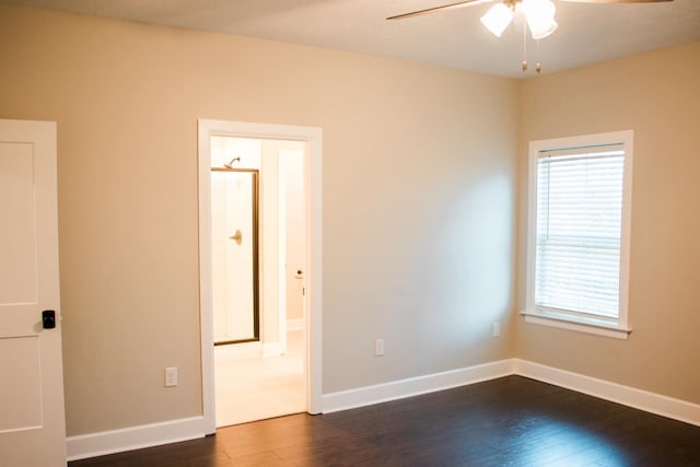 unfurnished room featuring a ceiling fan, baseboards, and dark wood-style flooring