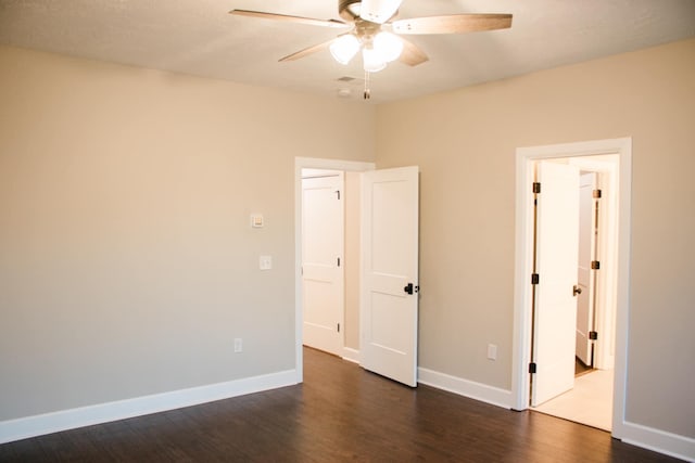 unfurnished bedroom featuring dark wood-type flooring, ceiling fan, and baseboards