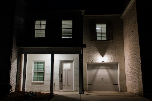 view of exterior entry with a garage and concrete driveway