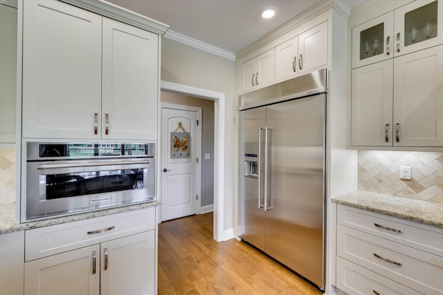 137 Elgin Ln, Mccormick, SC 29835 - kitchen featuring light wood finished floors, crown molding, white cabinetry, backsplash, and appliances with stainless steel finishes