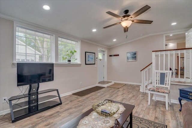 living room with lofted ceiling, ceiling fan, light wood-type flooring, and crown molding