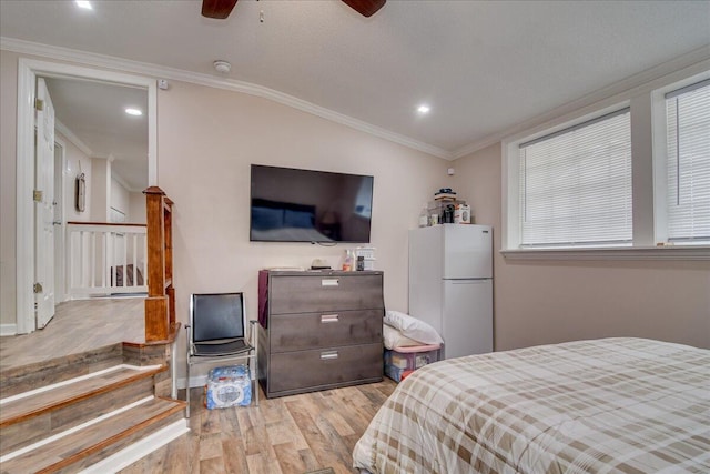 bedroom with ceiling fan, crown molding, vaulted ceiling, and white refrigerator