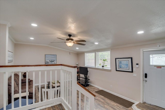 foyer featuring a textured ceiling, wood-type flooring, and crown molding