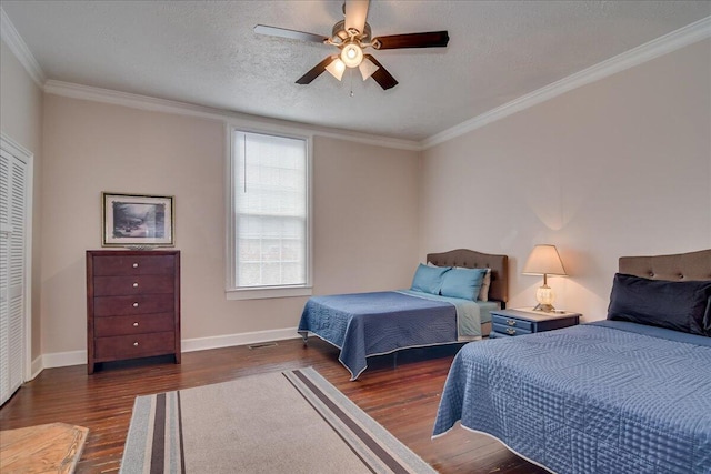 bedroom with ornamental molding, a textured ceiling, ceiling fan, dark hardwood / wood-style floors, and a closet