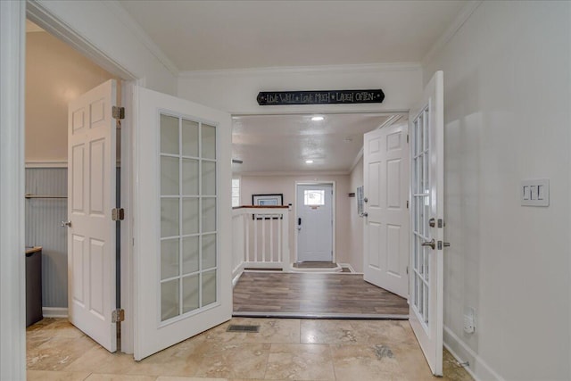 foyer entrance featuring crown molding and french doors