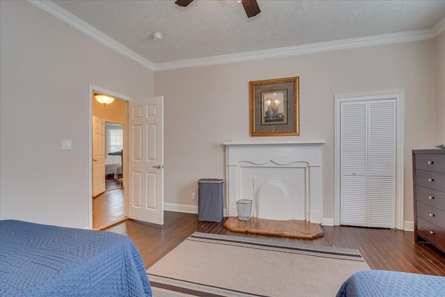 bedroom featuring a textured ceiling, ceiling fan, dark hardwood / wood-style floors, and crown molding