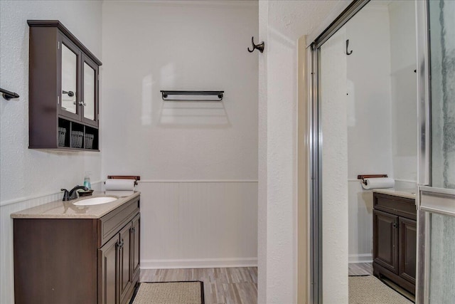 bathroom with hardwood / wood-style floors, vanity, and walk in shower