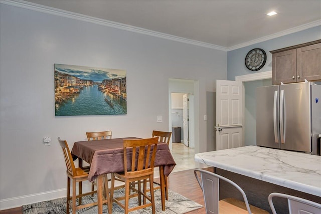 dining area featuring light hardwood / wood-style floors and crown molding