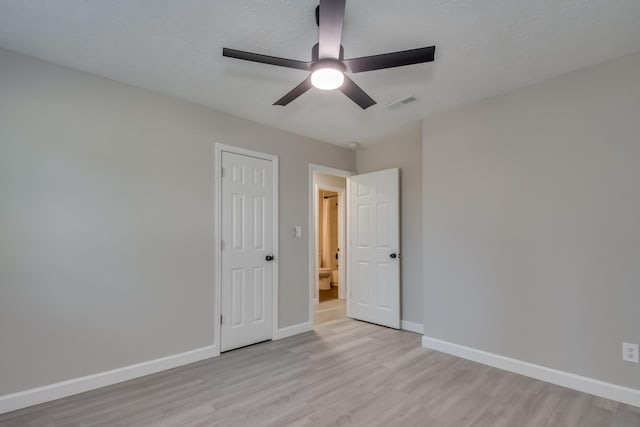 unfurnished room featuring light wood finished floors, visible vents, baseboards, ceiling fan, and a textured ceiling