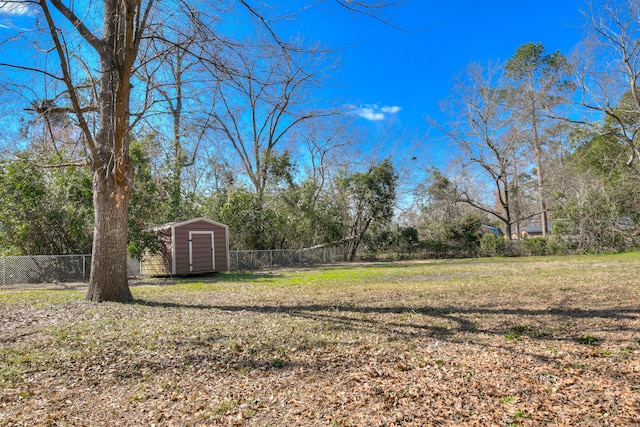 view of yard featuring a storage shed, an outdoor structure, and fence