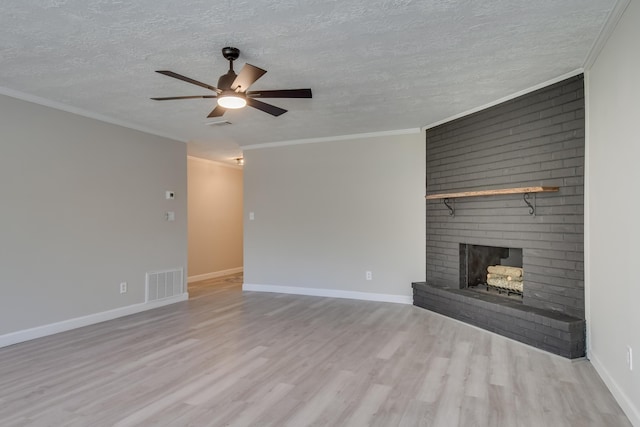 unfurnished living room with crown molding, a fireplace, visible vents, a ceiling fan, and wood finished floors