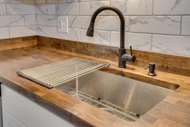 room details with a sink, wood counters, and decorative backsplash