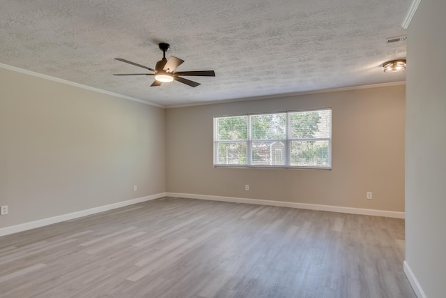 spare room with crown molding, baseboards, and wood finished floors