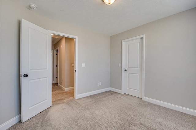 unfurnished bedroom featuring light colored carpet and a closet