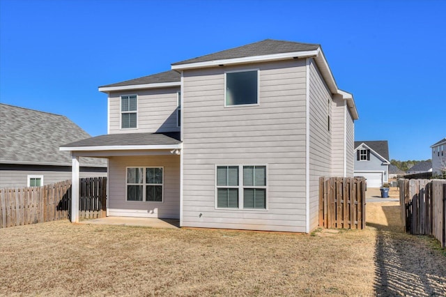 rear view of house featuring a lawn and a patio area