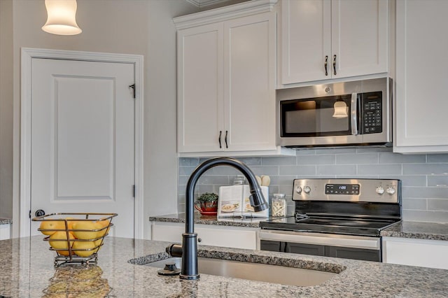 kitchen featuring white cabinets, stainless steel appliances, sink, stone countertops, and backsplash