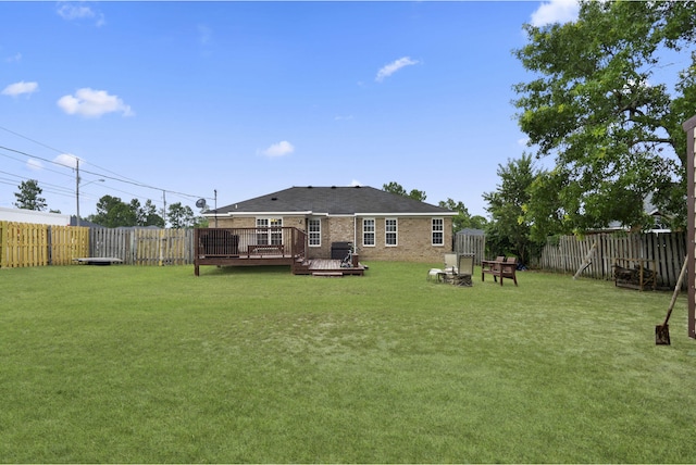 1518 Sandstone Ln, Hephzibah, GA 30815 - rear view of house with a wooden deck, brick siding, and a fire pit