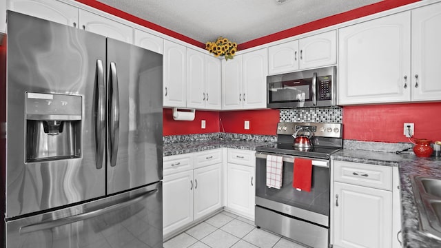 1518 Sandstone Ln, Hephzibah, GA 30815 - kitchen with stainless steel appliances, white cabinetry, light tile patterned floors, and a textured ceiling