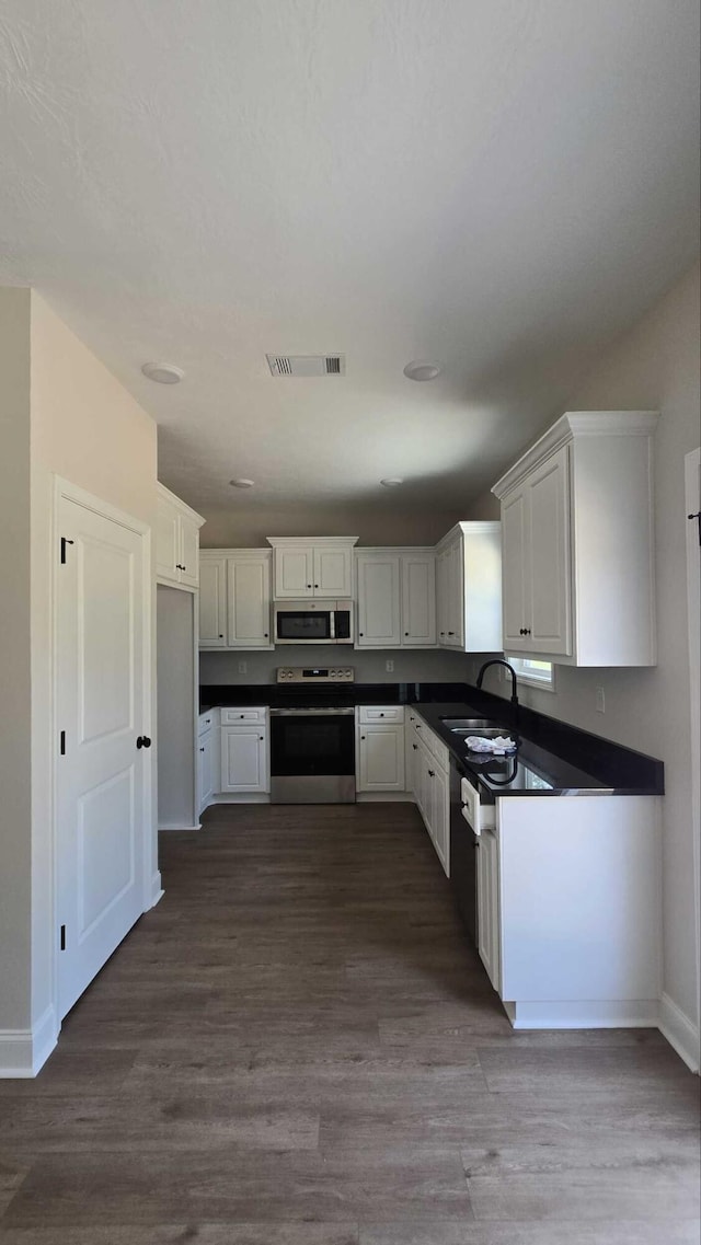 1759 Storm Branch Rd, Beech Island, SC 29842 - kitchen with stainless steel appliances, dark countertops, and dark wood-type flooring