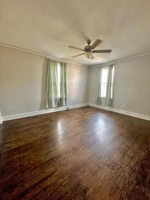 empty room with ceiling fan, baseboards, and dark wood-style flooring