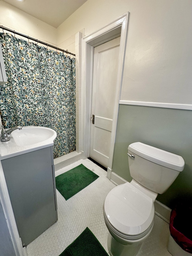 full bathroom featuring baseboards, toilet, tile patterned floors, vanity, and a shower stall